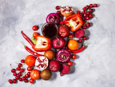 Beton zemin üzerine, üstten görünüm sağlıklı yemek için taze malzemelerle çiğ kırmızı organik sebze. Vegan veya diyet gıda kavramı