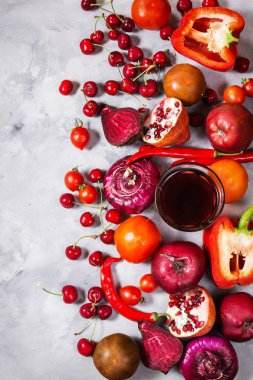 Beton zemin üzerine, üstten görünüm sağlıklı yemek için taze malzemelerle çiğ kırmızı organik sebze. Vegan veya diyet gıda kavramı