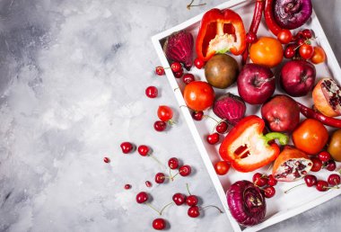 Üstten görünüm beton zemin üzerine beyaz tepsisinde sağlıklı yemek için taze malzemelerle çiğ kırmızı organik sebze