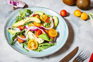 Domates ve beton zemin üzerine avokado salatası