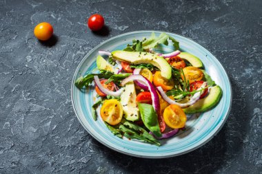 Domates ve taş zemin üzerine avokado salatası