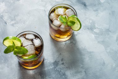 ROM ve kola. Cuba Libre içki kireç ve rustik beton masada buz ile