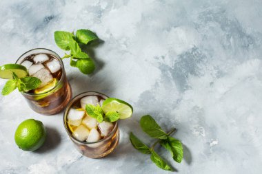 ROM ve kola. Cuba Libre içkiyle kireç ve buz rustik beton masada. Kopya alanı