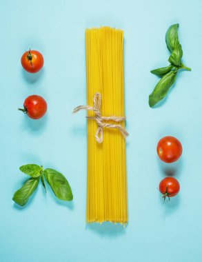 İtalyan spagetti makarna demet mavi arka plan üzerinde yalan dize ile bağlı. Üstten görünüm