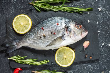 Karanlık taş zemin üzerine limonlu çiğ taze dorado. Üstten görünüm