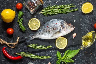 Karanlık taş zemin üzerine limonlu çiğ taze dorado. Üstten görünüm