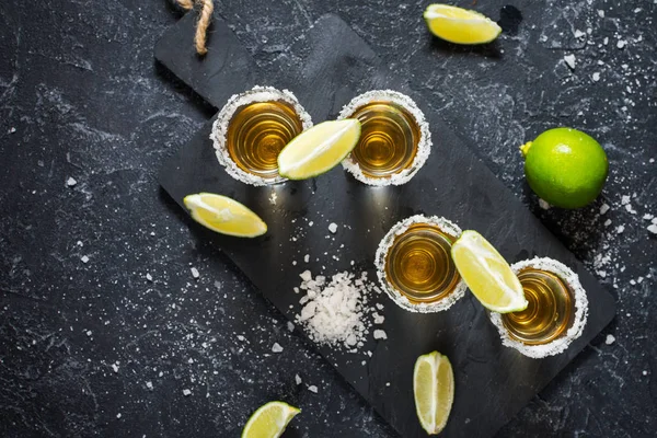 Mexicaanse Gouden Tequila Met Limoen Zout Zwarte Stenen Achtergrond Bovenaanzicht — Stockfoto