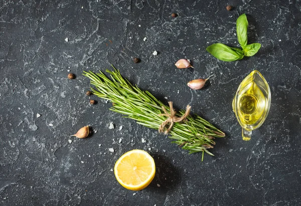 Rosemary, limon biber ve sarımsak karanlık taş masada. Malzemeler. Kopya alanı ile üstten görünüm.