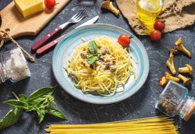 Cantharellus cibarius mantar ve malzemeler bir karanlık taş veya beton arka plan ile makarna