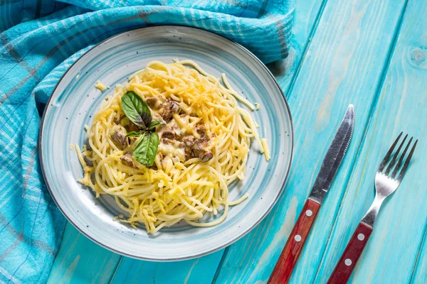 Cantharellus cibarius mantar ve malzemelerin üzerine mavi ahşap arka plan ile makarna.