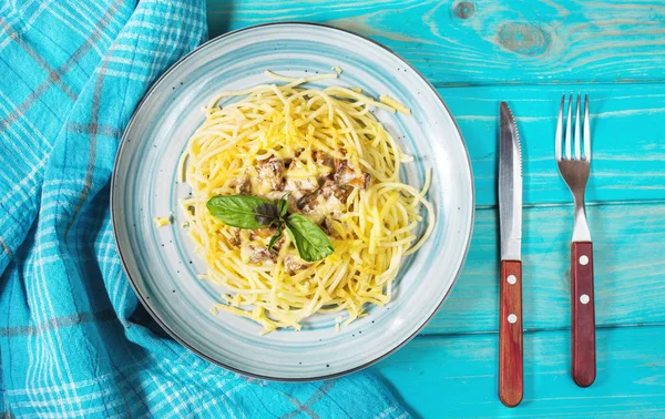 Cantharellus cibarius mantar ve malzemelerin üzerine mavi ahşap arka plan ile makarna. Üstten görünüm.