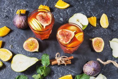 Kokteyl meyve sangria ile elma, portakal, incir, üzüm, nane taş masanın üzerine