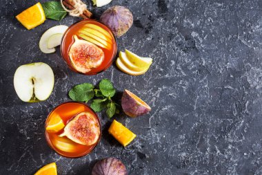 Kokteyl meyve sangria ile elma, portakal, incir, üzüm, nane taş masanın üstünde. Polis y alanı