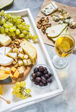 Peynir ahşap masa, zeytin, meyve, badem ve şarap gözlük beton masada beyaz tepsi üzerinde farklı türleri