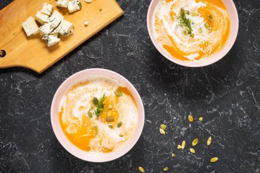 Taş zemin üzerine beyaz peynir ile kalın balkabağı çorbası. Üstten görünüm