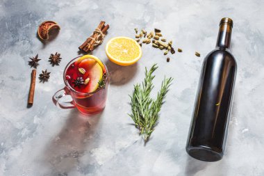 Şarap, mulled şarap ve beton zemin üzerine malzemeler ile cam şişe.