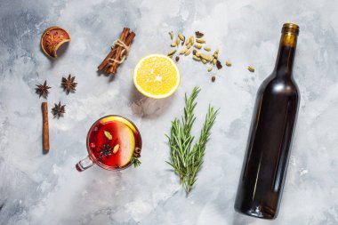 Şarap, mulled şarap ve beton zemin üzerine malzemeler ile cam şişe. Üstten görünüm