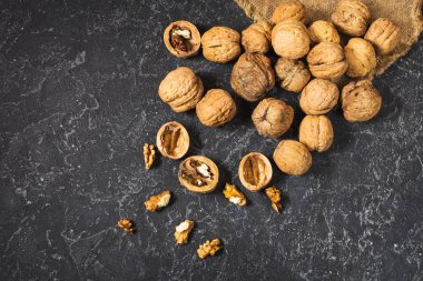 Karanlık bir taş zemin üzerine ceviz taneleri. Üstten görünüm