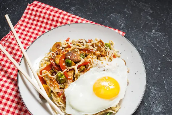 Udon erişte ile tavuk siyah taş zemin üzerine tavada