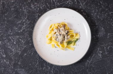 Makarna petrol ve siyah taş zemin üzerine sos ile. Üstten görünüm