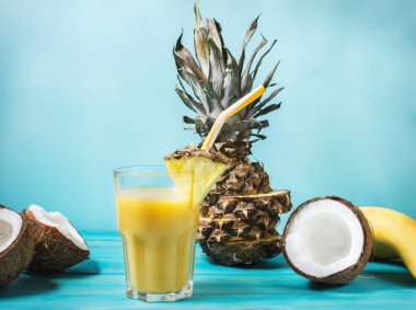 Pineapple, banana and coconut cocktail or juice in glass on a concrete background