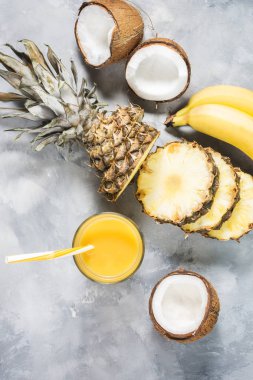 Ananas, muz ve Hindistan cevizi kokteyl veya beton zemin üzerine cam suyu. Üstten görünüm