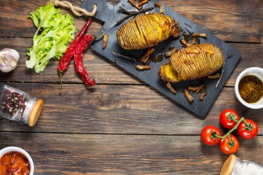 Ahşap zemin üzerine kavrulmuş hasselback patates. En iyi görünüm ve kopya alanı