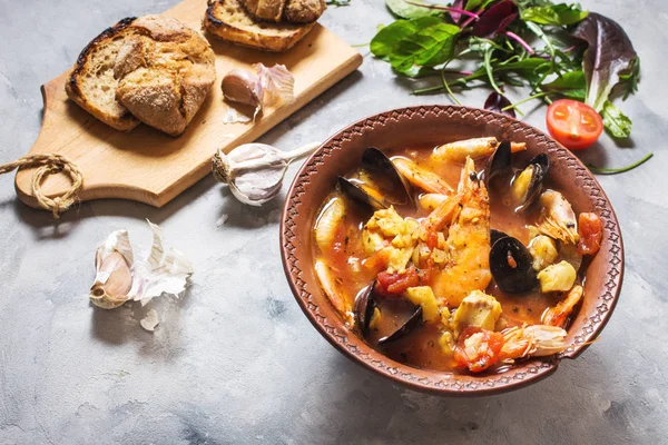 French fish soup Bouillabaisse with seafood, salmon fillet, shrimp, mussels on concrete background. Delicious dinner — Stock Image French Fish Soup Bouillabaisse Seafood Salmon Fillet Shrimp Mussels Concrete Stock Picture