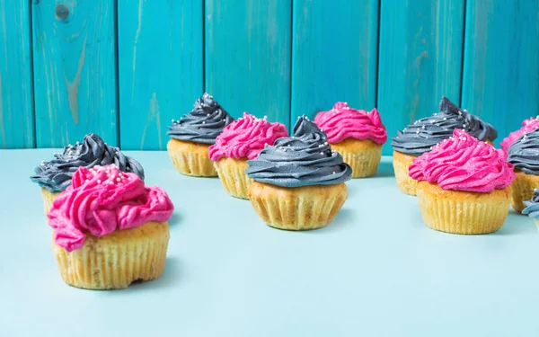 Sabroso Rosado Gris Cupcakes Una Fila Sobre Fondo Azul —  Fotos de Stock