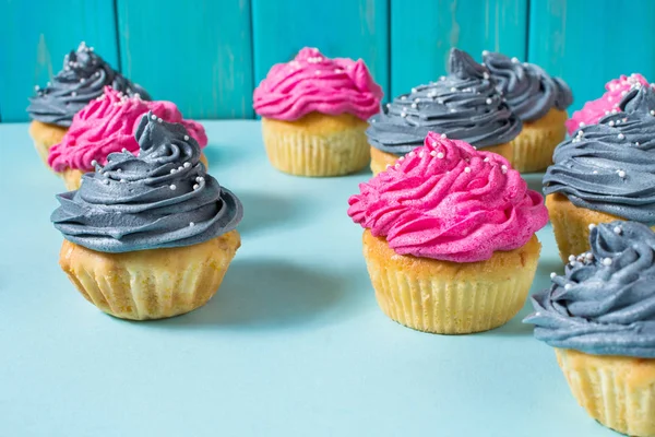 Sabroso Rosado Gris Cupcakes Una Fila Sobre Fondo Azul —  Fotos de Stock