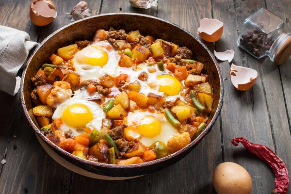 Домашний сердечный завтрак Сковорода с картофелем яиц и мясом на деревянном столе — стоковое фото