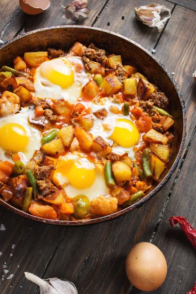 Домашний сердечный завтрак Сковорода с картофелем яиц и мясом на деревянном столе — стоковое фото
