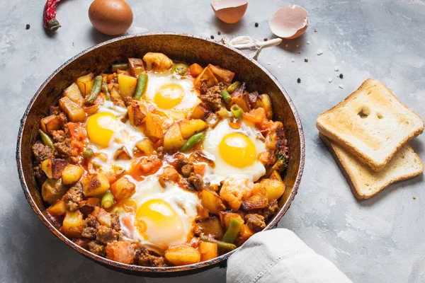 Домашний сердечный завтрак Сковорода с картофелем яиц и мясом на бетонном столе — стоковое фото