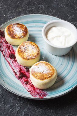 Süzme peynir taş zemin üzerine krep. Ekşi krema ile Syrniki. Ev yapımı yiyecek