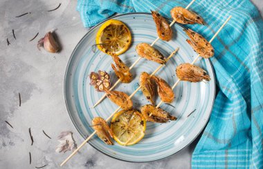 Izgara karides şiş şifreli otlar, sarımsak ve limon beton zemin üzerine. Deniz ürünleri, shelfish.