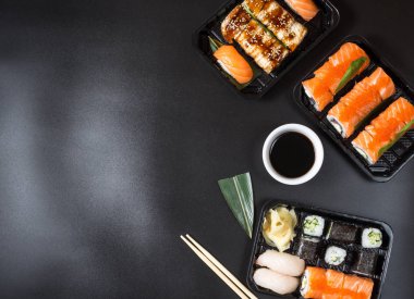 Çeşitli Sushi çeşitleri siyah arka planda servis edilmiştir
