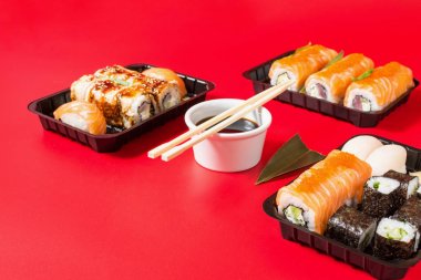 Çeşitli Sushi çeşitleri kırmızı arka planda servis edildi