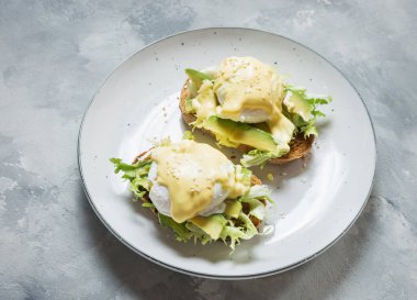 Beton arka plan üzerinde avokado ile Yumurta Benedict.