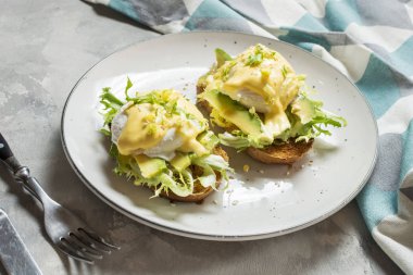 Beton arka plan üzerinde avokado ile Yumurta Benedict.