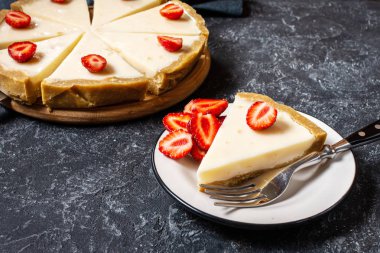 Taş arka planda dilimlenmiş taze çilek ile ev yapımı cheesecake