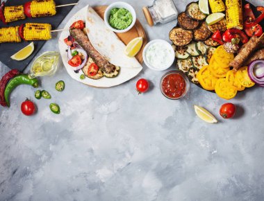 Beton bir arka plan üzerinde çeşitli lezzetli ızgara sebze ve döner kebap. Yaz yemeği barbekü.