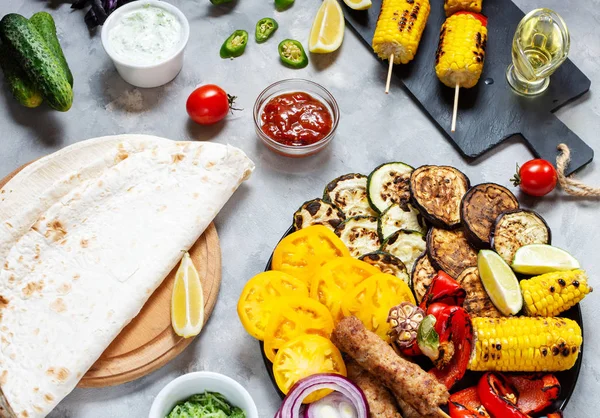Beton bir arka plan üzerinde çeşitli lezzetli ızgara sebze ve et. Yaz yemekleri.