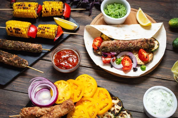 Ahşap bir arka plan üzerinde çeşitli lezzetli ızgara sebze ve döner kebap. Yaz yemekleri.