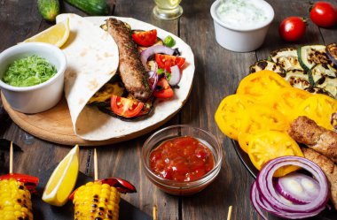Ahşap bir arka plan üzerinde çeşitli lezzetli ızgara sebze ve döner kebap. Yaz yemekleri.