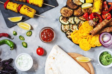 Beton bir arka plan üzerinde çeşitli lezzetli ızgara sebze ve et. Yaz yemeği barbekü.