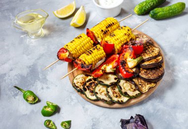 Beton bir arka plan üzerinde çeşitli lezzetli ızgara sebze. Yaz barbekü.