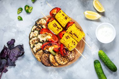 Beton bir arka plan üzerinde çeşitli lezzetli ızgara sebze. Yaz yemeği barbekü.