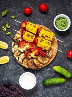 Koyu taş arka plan üzerinde çeşitli lezzetli ızgara sebzeler. Yaz yemeği barbekü.