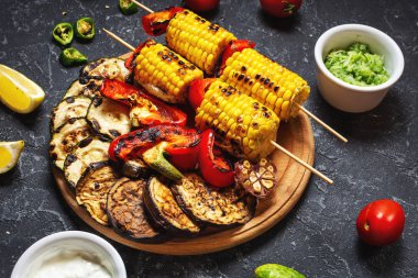 Koyu taş arka plan üzerinde çeşitli lezzetli ızgara sebzeler. Yaz barbekü.