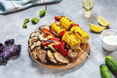 Beton bir arka plan üzerinde çeşitli lezzetli ızgara sebze. Yaz barbekü.